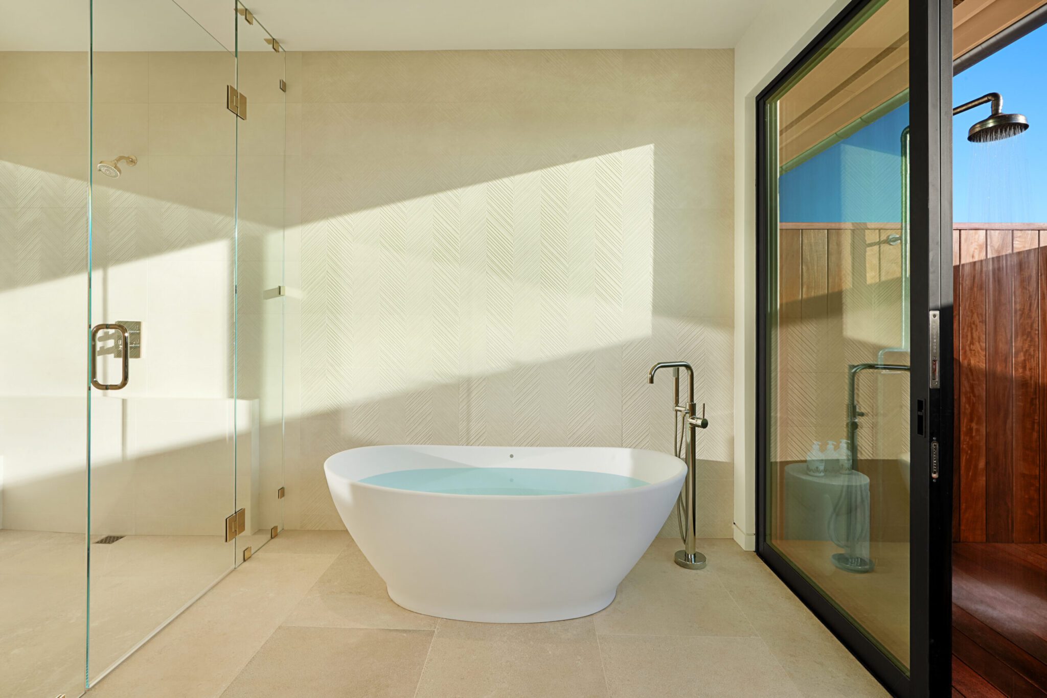A bathroom with a large tub and glass shower door.