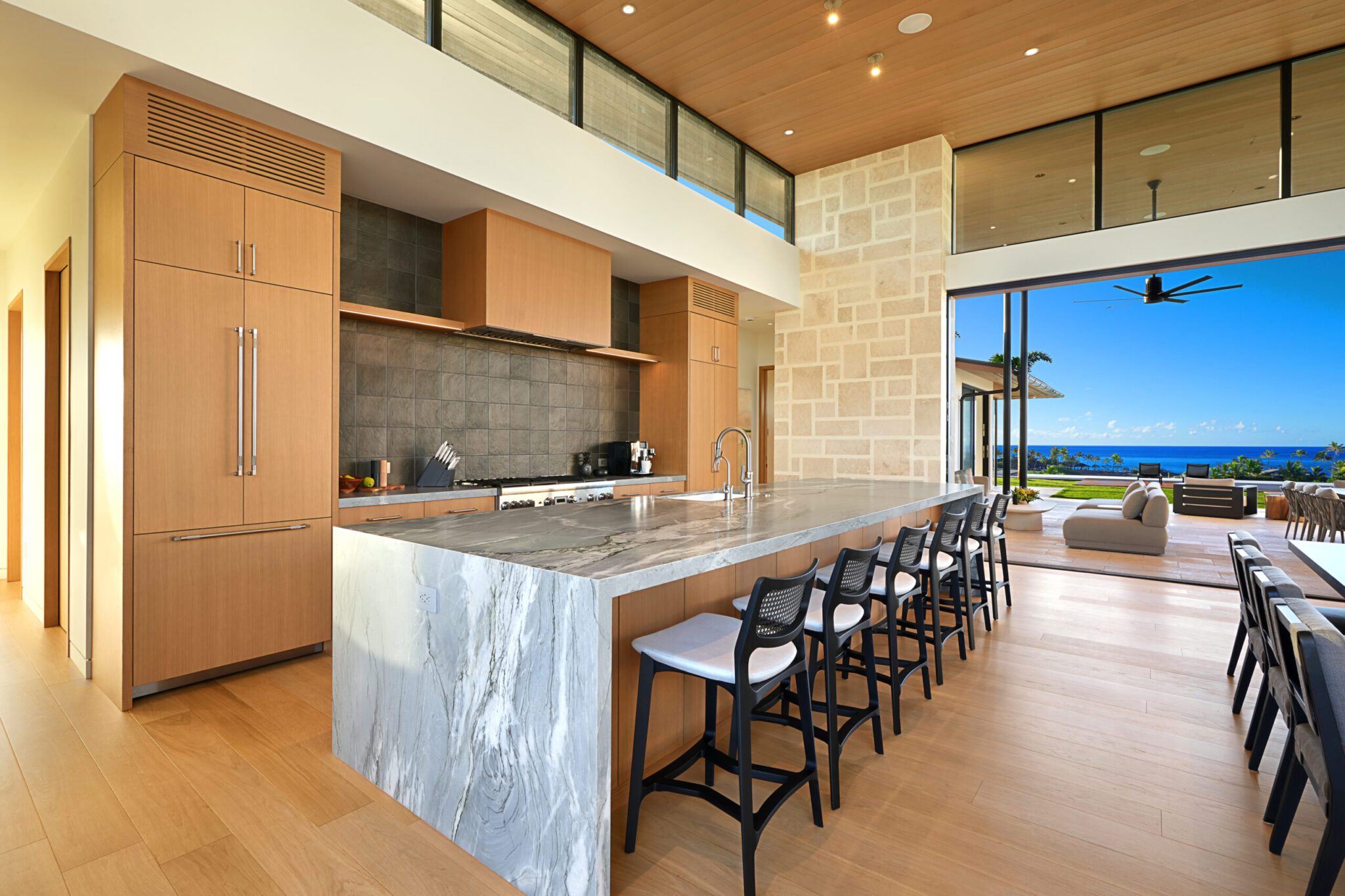 A large kitchen with marble counter tops and wooden cabinets.