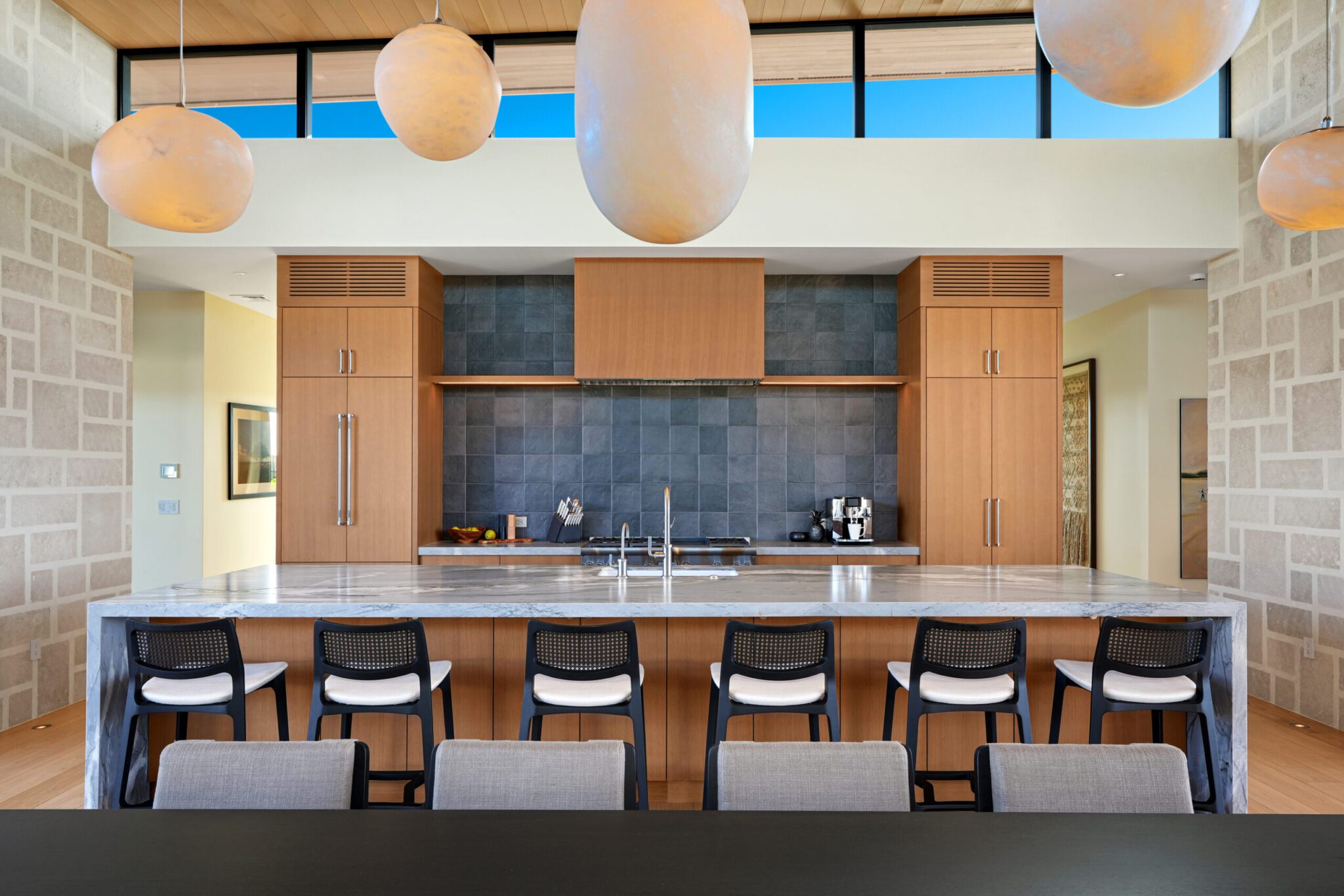 A kitchen with lots of counter space and chairs.