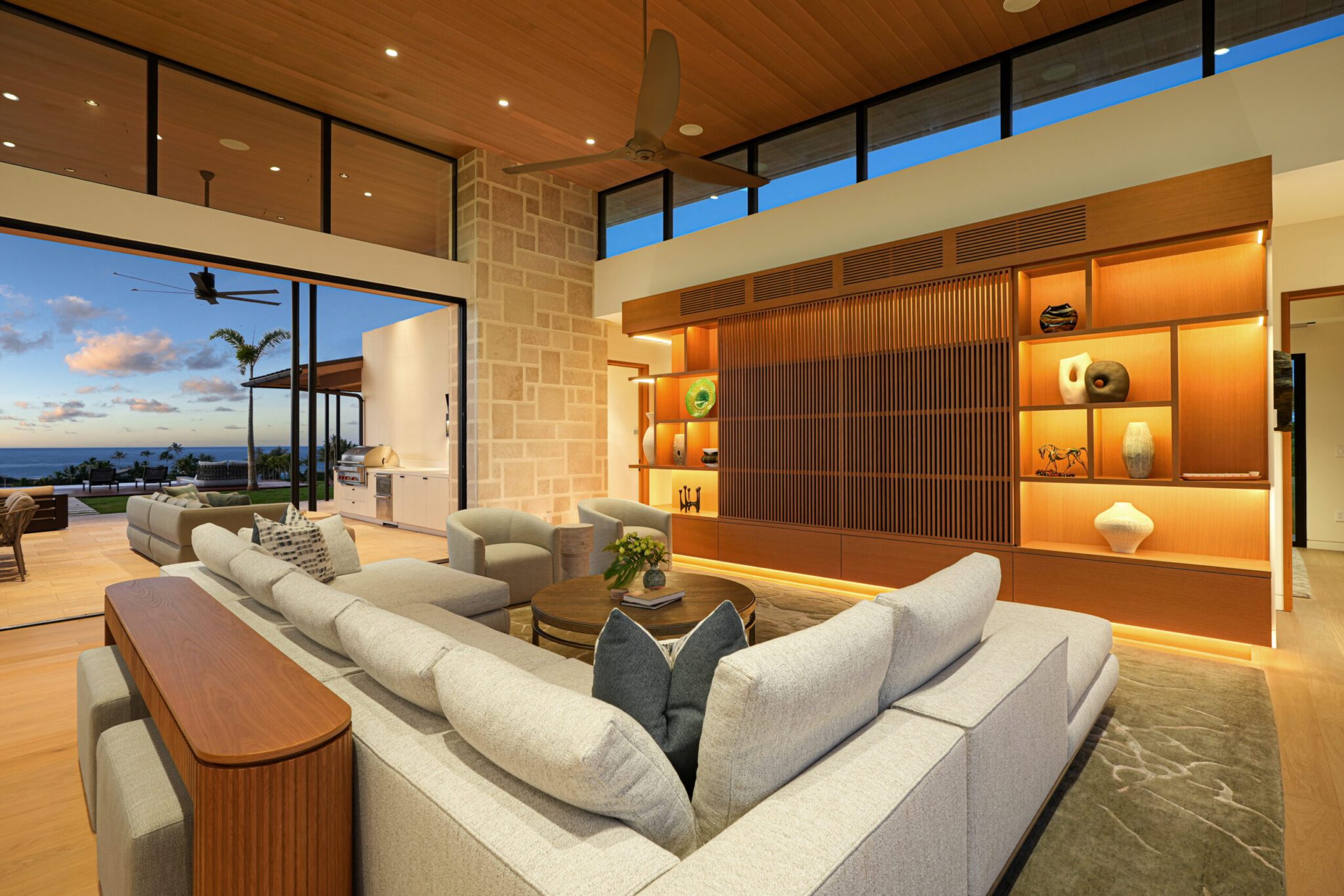 A living room with large windows and white furniture.