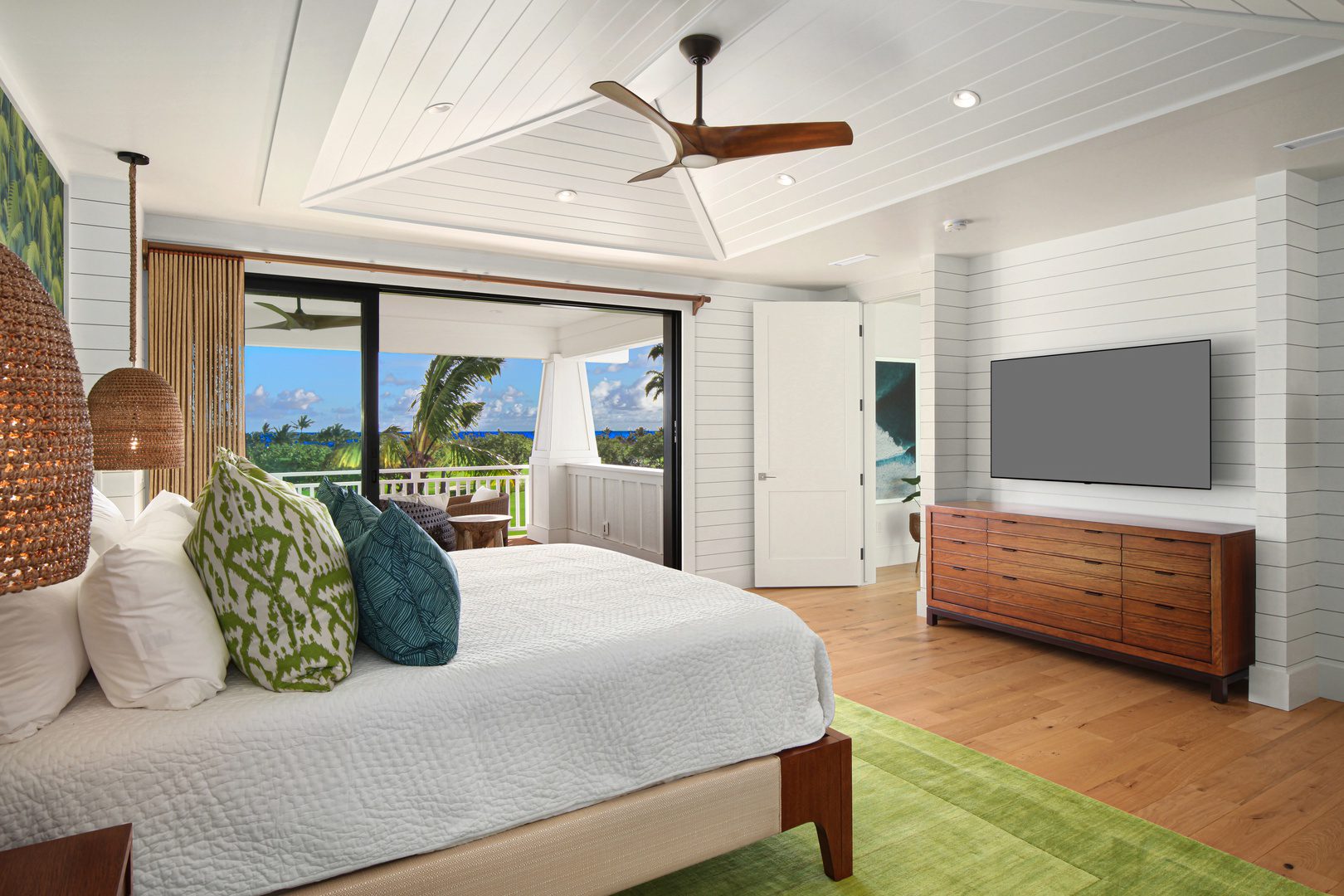 A bedroom with a bed, dresser and tv.
