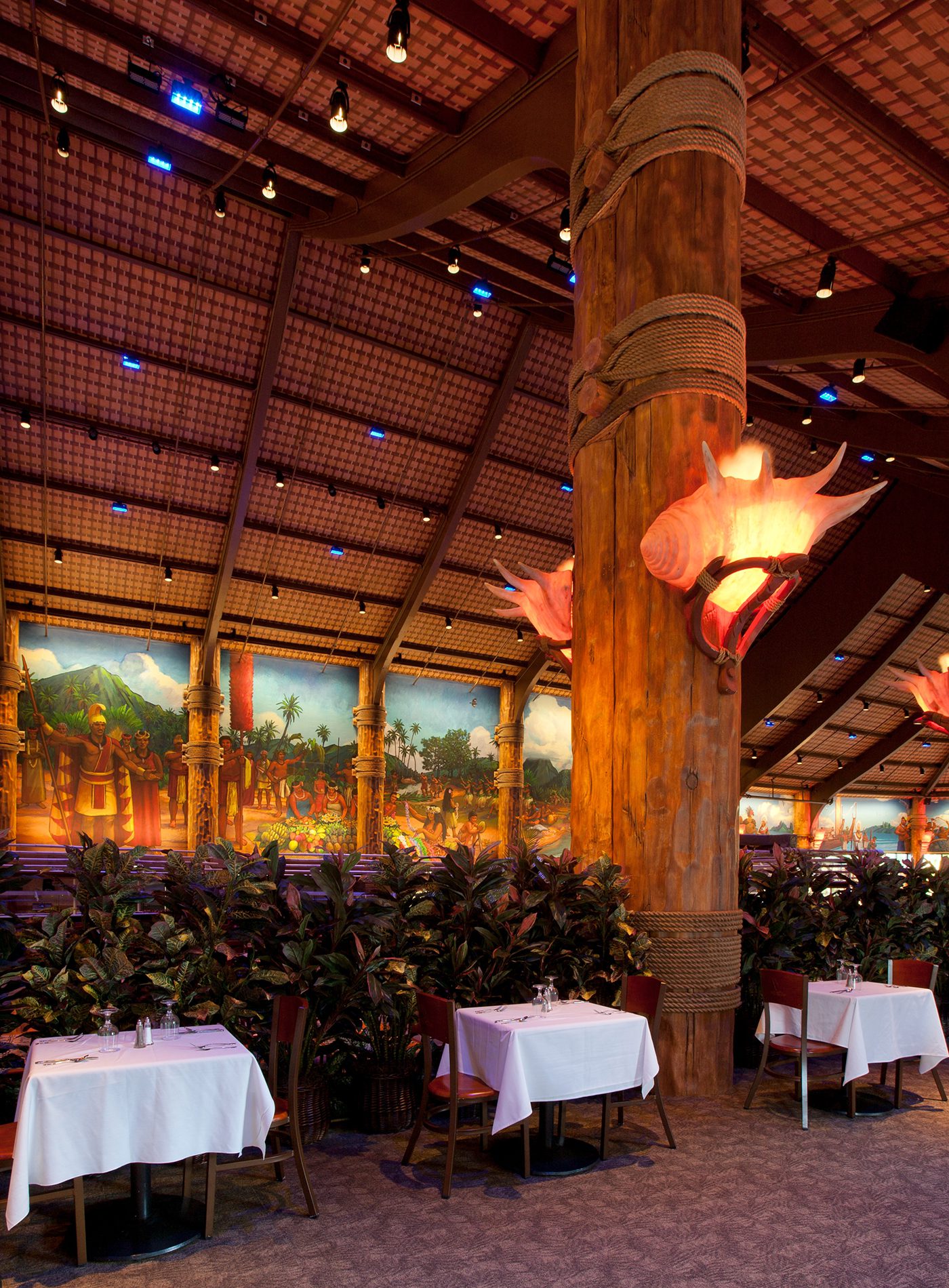 A restaurant with tables and chairs set up for dinner.