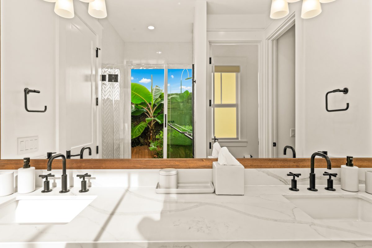 A bathroom with two sinks and a large mirror.