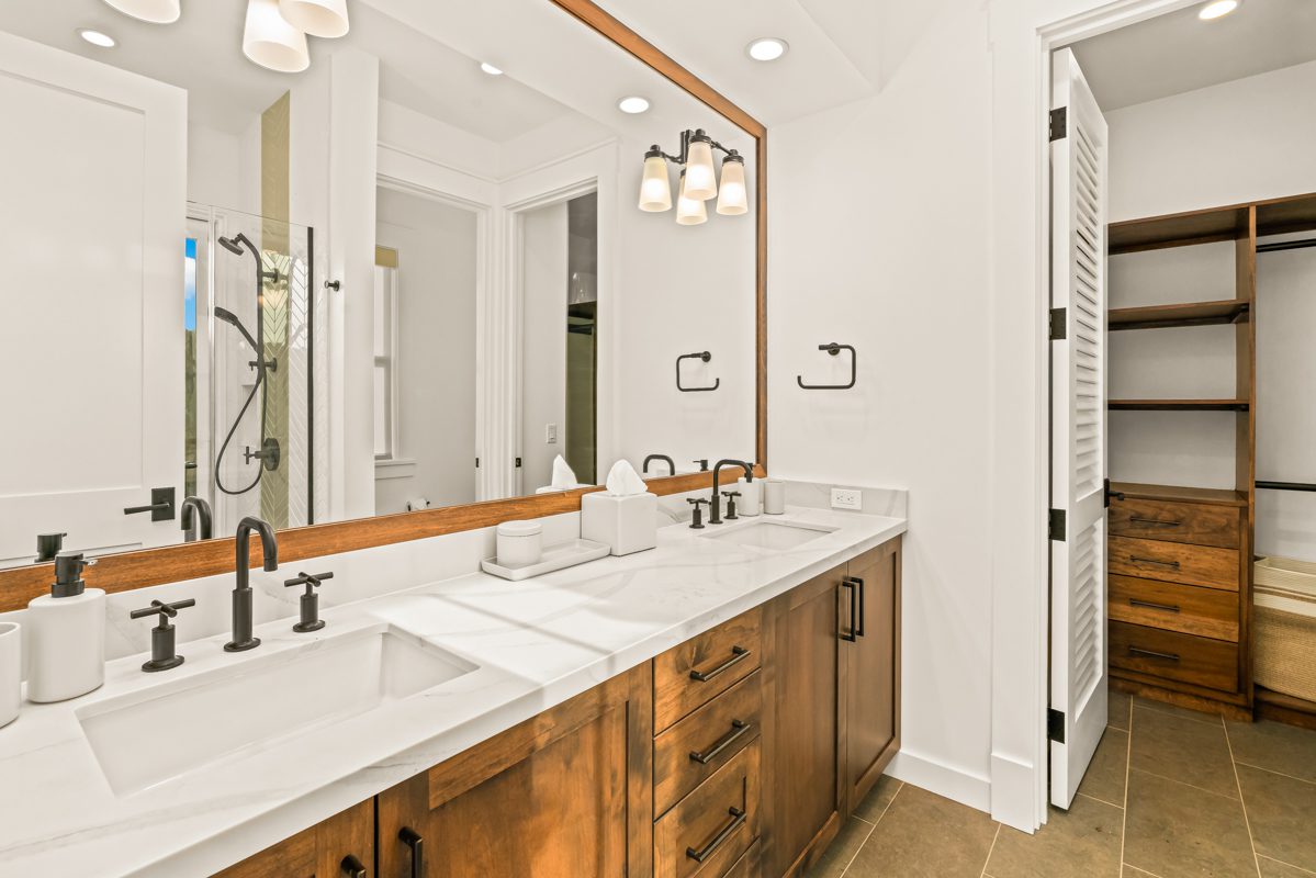 A bathroom with two sinks and a large mirror.