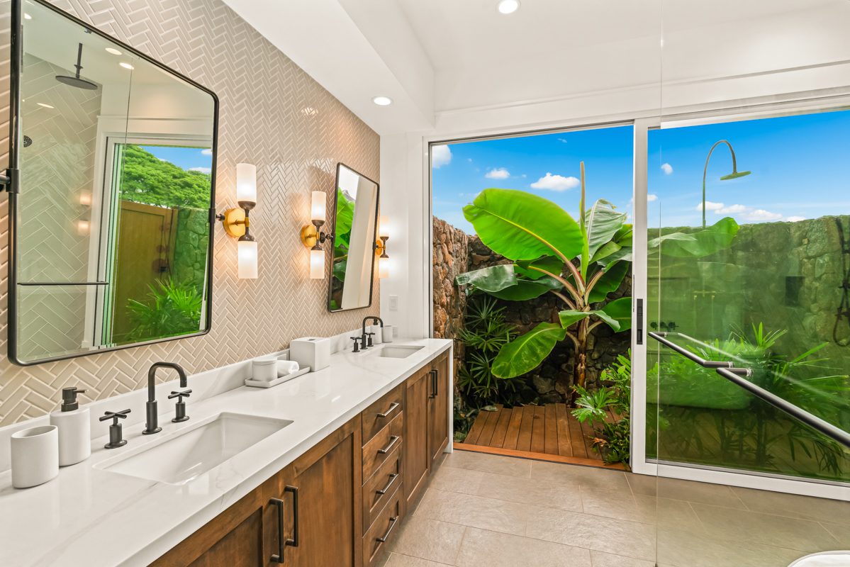 A bathroom with two sinks and a large sliding glass door.