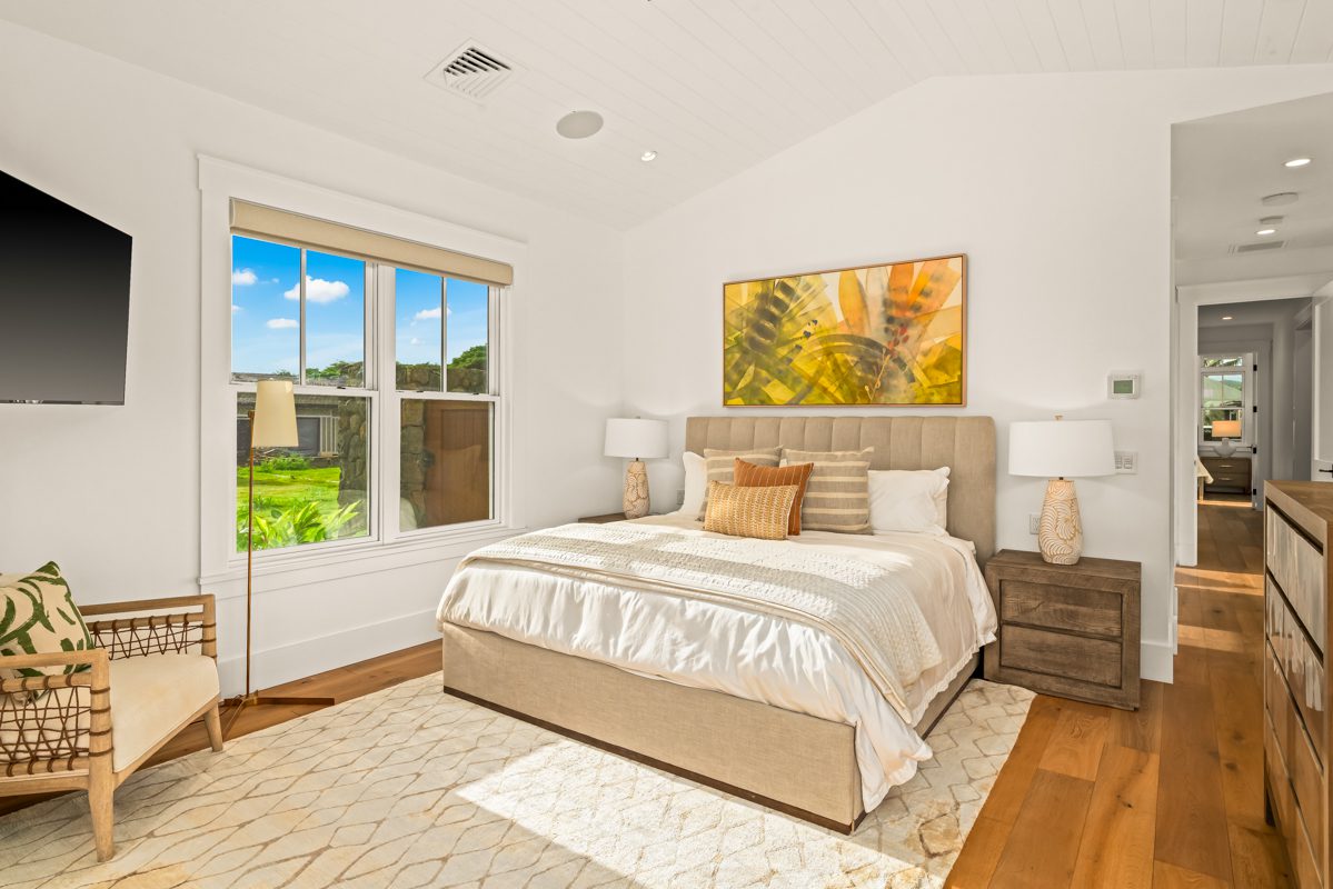 A bedroom with a large bed and white walls.