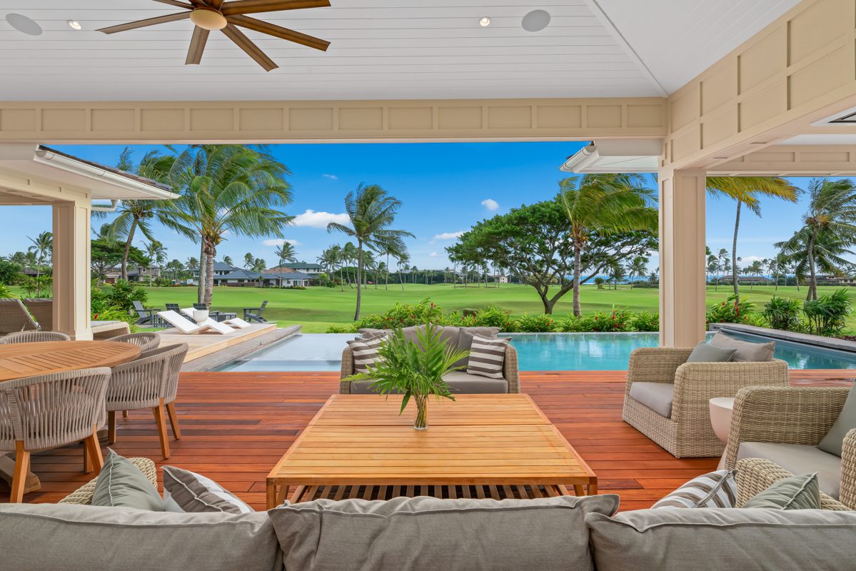 A large open porch with furniture and a pool.
