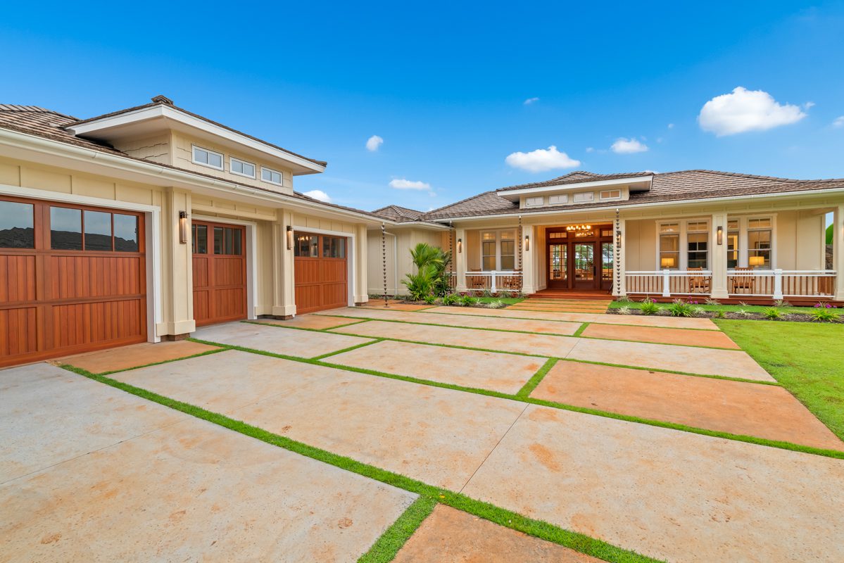 A large house with a big driveway and lots of grass.